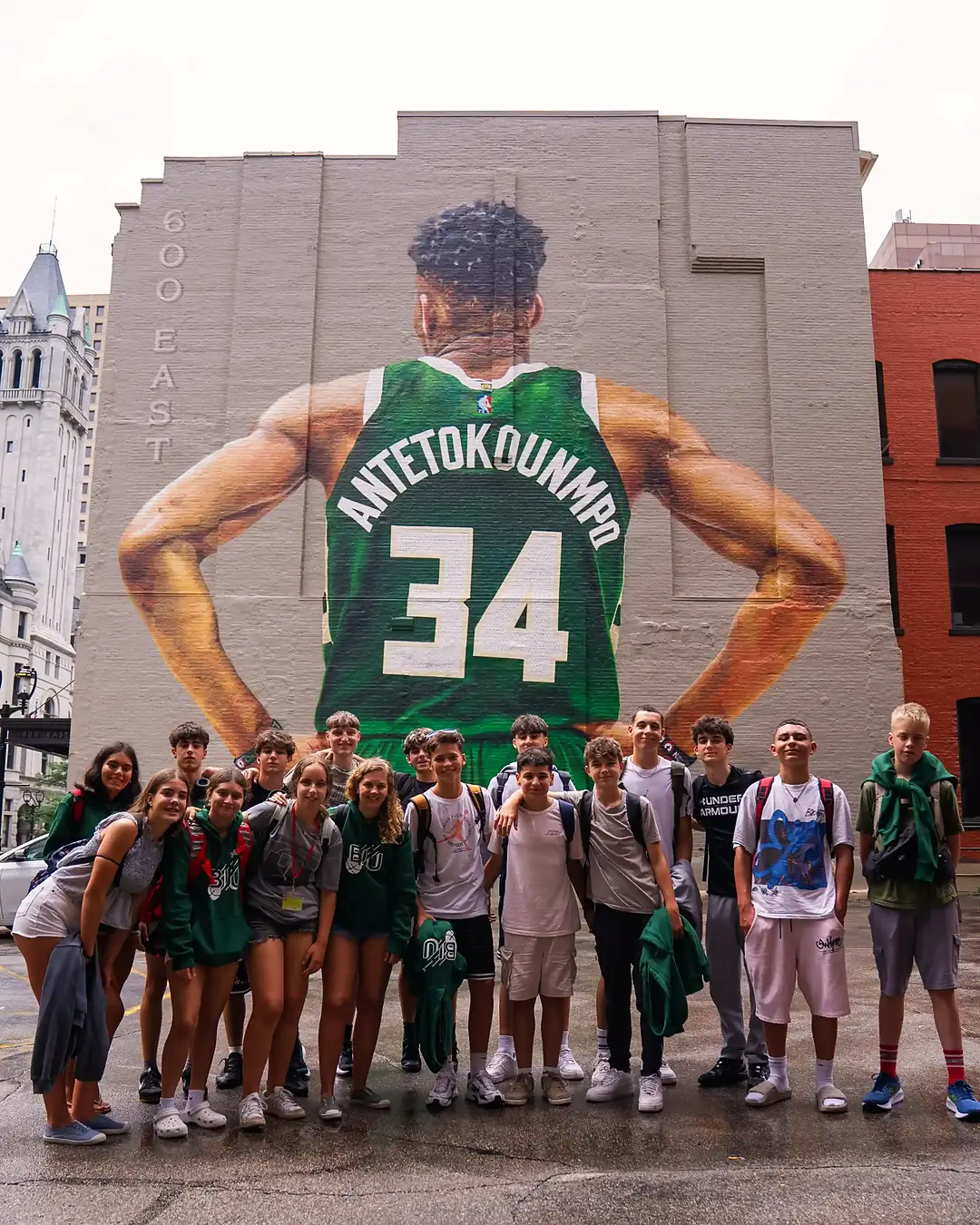 Grupo del campus de baloncesto de Milwaukee frente al mural de Giannis Antetokounmpo