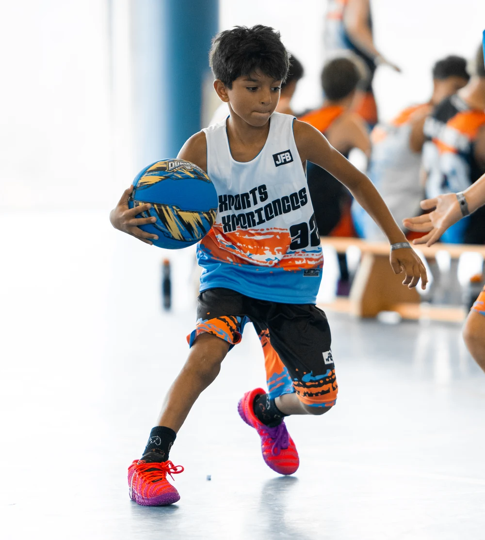 Niño botando el balón en un entrenamiento de minibasket del campus de baloncesto Xports Xperiences